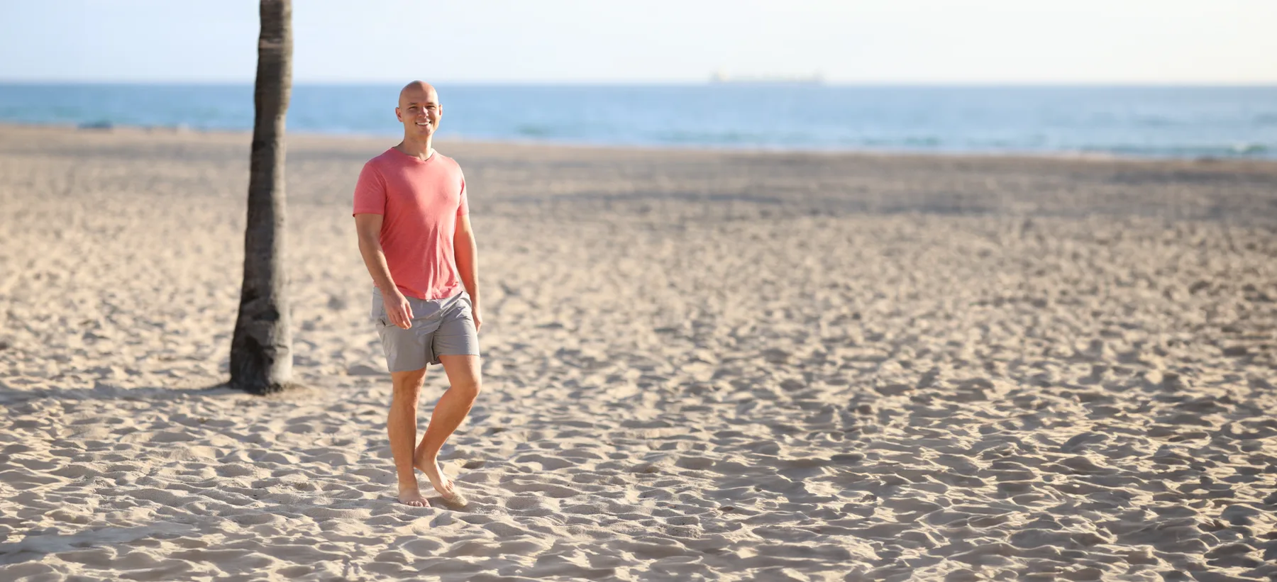 Anthoney walking barefoot on the beach